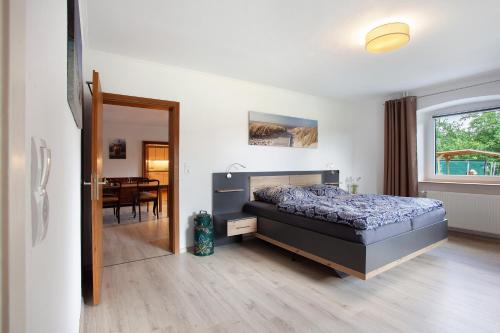 a bedroom with a bed and a dining room at Ferienwohnung auf dem Ennerthof in Arnsberg