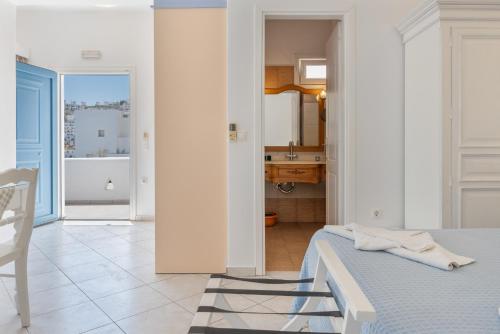 a white bedroom with a bed and a bathroom at Caldera Studios in Astypalaia