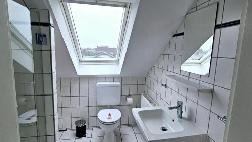 a bathroom with a toilet and a sink and a window at Büsummchen in Büsum