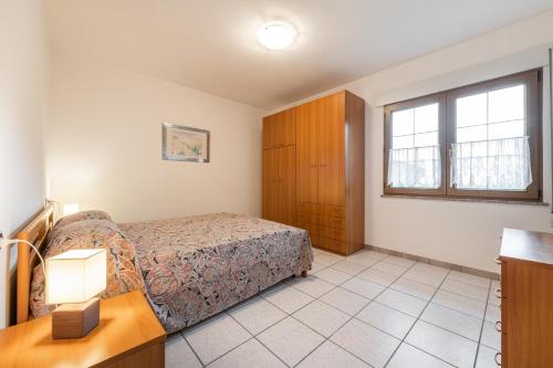 a bedroom with a bed and a dresser and a window at Casa Colonia 1 in SantʼAnna Arresi
