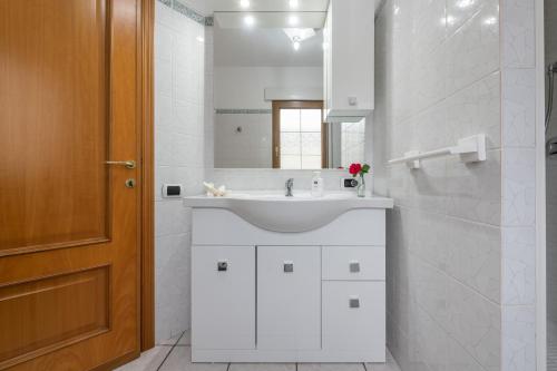 a white bathroom with a sink and a mirror at Casa Colonia 1 in SantʼAnna Arresi