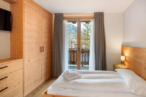 a bedroom with a bed and a large window at Quattropassi Bormio Mortirolo in Bormio