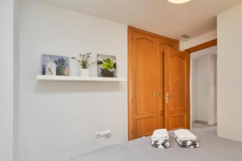 a kitchen with white walls and a wooden cabinet at Las Lomas de Marina del Este in Almuñécar