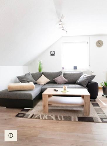 a living room with a couch and a coffee table at Ferienwohnung Am Palmengarten in Marktbergel