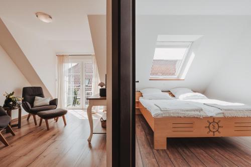 a bedroom with a bed and a chair and a window at Skippers Inn in Baltrum