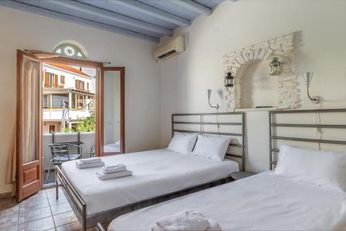 a bedroom with two beds and a balcony at En Tino 4 in Tinos