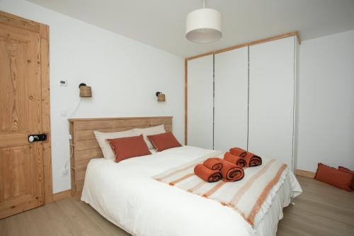a bedroom with a large white bed with two towels on it at Appartement de charme - La Tour in La Tour