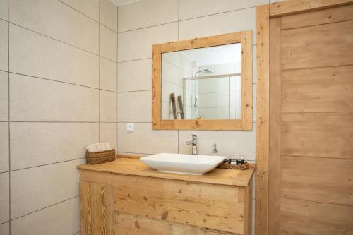 a bathroom with a sink and a mirror at Appartement de charme - La Tour in La Tour