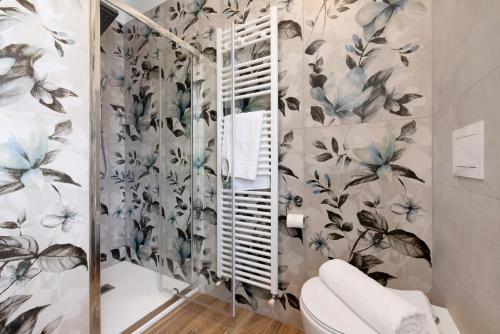 a bathroom with a toilet and floral wallpaper at Vigilio house in Calco