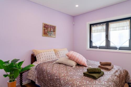 a bedroom with a bed with pillows and a window at Porto Nova Vivenda em Lever in Lever
