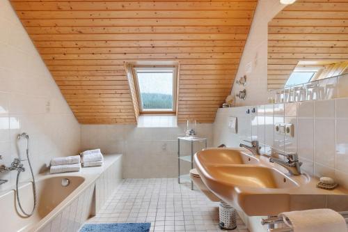 a bathroom with a tub and a sink and a bath tub at Haus Marianne Dörflinger in Schluchsee