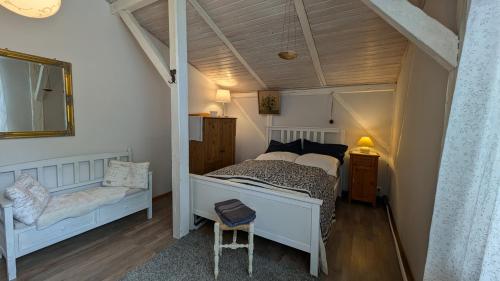 a bedroom with a white bed and a chair at Kleines Quickborn in Quickborn