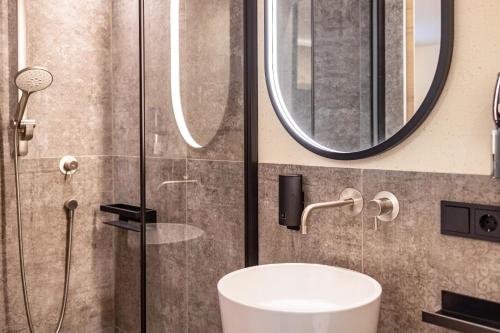 a bathroom with a shower and a sink and a mirror at Avia Living Elisabeth in Brunico