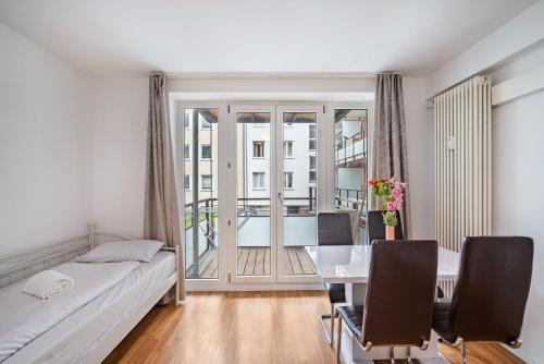 a bedroom with a desk and a table with chairs at Aldars Urban Suite No.10 in Munich