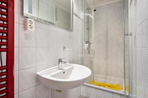a white bathroom with a sink and a shower at Prerow Am Deich - Ferienwohnung 2 in Prerow