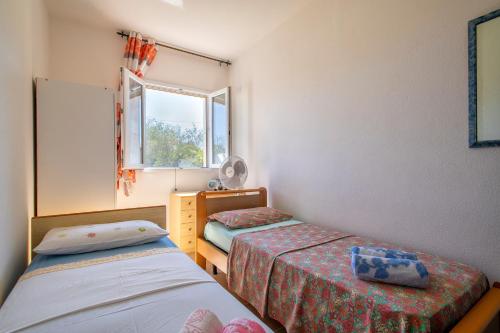a small room with two beds and a window at Gadem House in Alghero