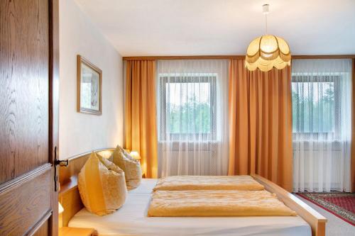 a bedroom with a bed and a chandelier at Ferienwohnungen Landhaus Strell in Bad Griesbach