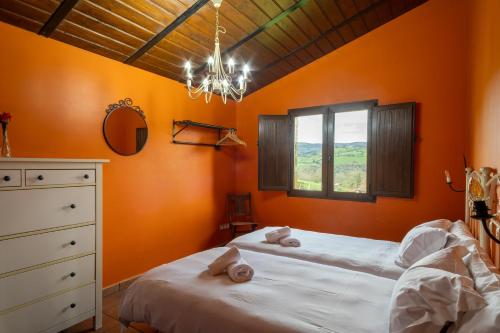 ein Schlafzimmer mit orangefarbenen Wänden, einem Bett und einem Fenster in der Unterkunft Amama in Karrantza