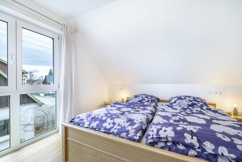a bed in a room with a large window at Ferienwohnung Schatz in Albstadt