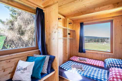 ein kleines Haus mit einer Couch und einem Fenster in der Unterkunft Tiny Houses der Dorfscheune in Bieselberg