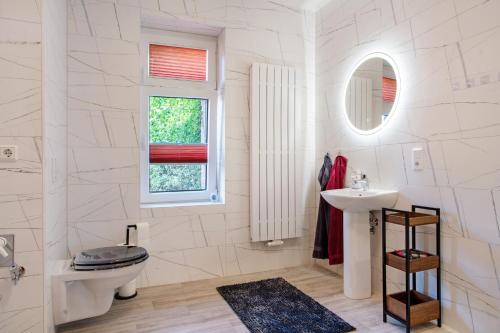 a white bathroom with a toilet and a sink at Ferienhaus Dorfidyll in Bugewitz