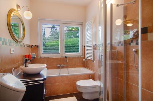 a bathroom with a tub and a sink and a toilet at Ferienwohnung Refugium Schönenberg in Sigmaringen