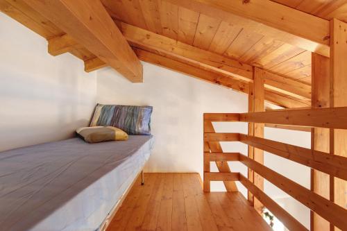 a bed in a room with wooden ceilings at Grace house holiday in San Fedele Intelvi