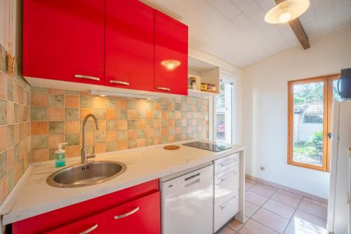 a kitchen with red cabinets and a sink at Mazet à Nimes in Nîmes