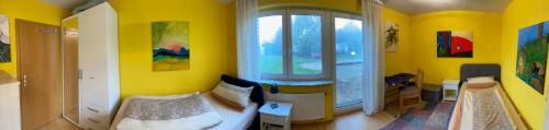 a yellow room with a bed and a window at Ferienwohnung Ingrid Rautenberg in Krautheim