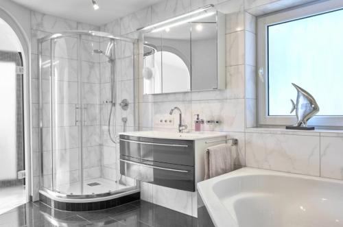 a bathroom with a tub and a sink and a shower at Haus Seeblick in Sipplingen