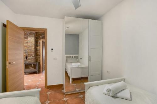 a white bedroom with a bed and a mirror at Finca Keyfer in Vilaflor