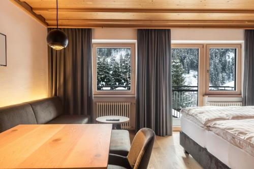 a bedroom with a bed and a table in a room at La Grambla App Saslonch 1 in Santa Cristina Gherdëina