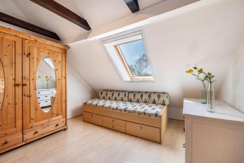 a small attic room with a bench and a window at Dat Haddehuus in Wangerland