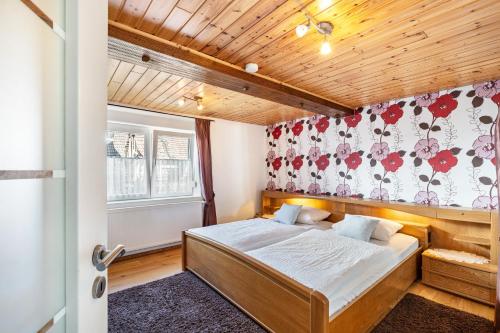 a bedroom with a bed with a floral wallpaper at Gästehaus Gross in Neustadt an der Weinstraße