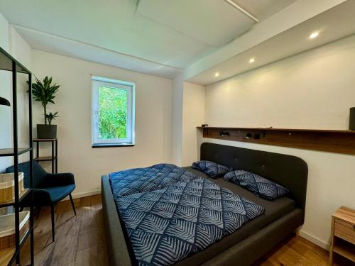 a bedroom with a bed and a chair and a window at Ferienhaus Ahaus in Ahaus