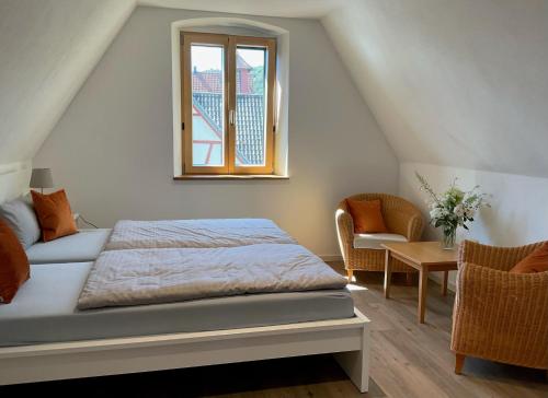 a bedroom with a bed and a window and a chair at Zauberhaftes Franken erleben in Gräfendorf