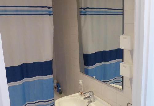 a bathroom with a sink and a shower curtain at Sunny apartment with pool in Tossa de Mar