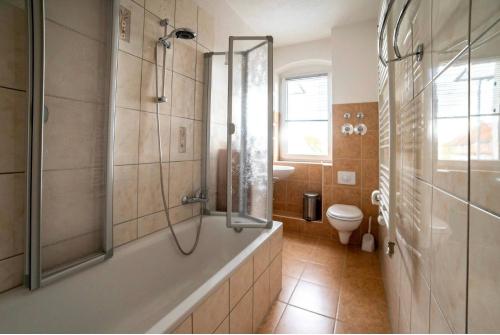 a bathroom with a shower and a tub and a toilet at Moderne Ferienwohnung in der Stadt in Forst