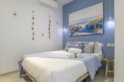 a bedroom with a large bed with blue walls at Apartamento Tarifa Dream B 08 in Tarifa