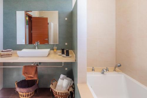 a bathroom with a sink and a tub and a mirror at Finca Bionic in Artá