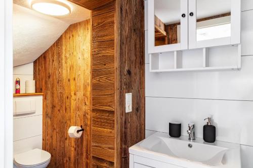 a bathroom with a sink and a wooden door at Feichtenhäusl app 1 in Westendorf
