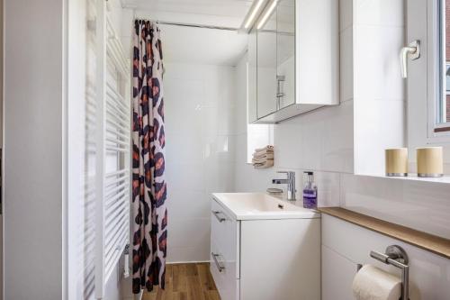 a small white bathroom with a sink and a mirror at Ferienwohnung Halunder in Leck