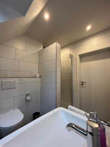 ein weißes Badezimmer mit Badewanne und Toilette in der Unterkunft Seeterrasse in Versmold