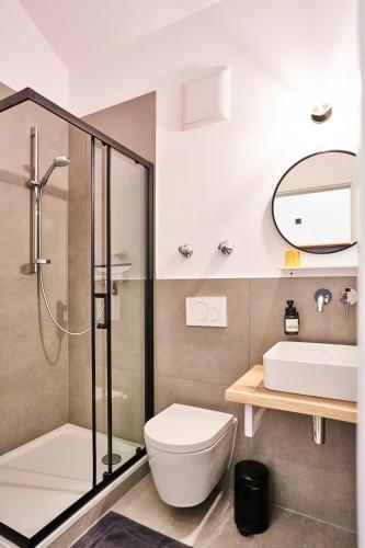 a bathroom with a shower and a toilet and a sink at Alte Seifensiederei - Astrid in Bad Tölz