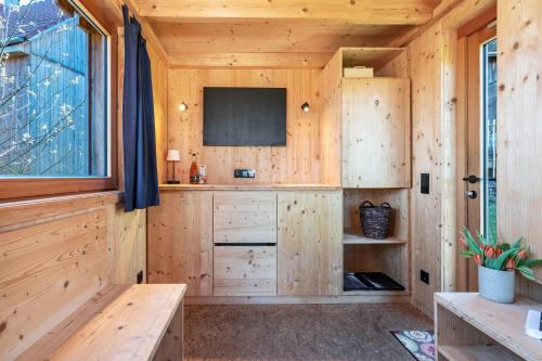 eine Holzhütte mit Fernseher und Fenster in der Unterkunft Tiny Houses der Dorfscheune in Bieselberg