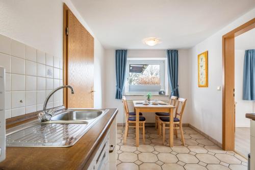 a kitchen with a sink and a table with chairs at Fewo Nissen Dagebüll in Dagebüll