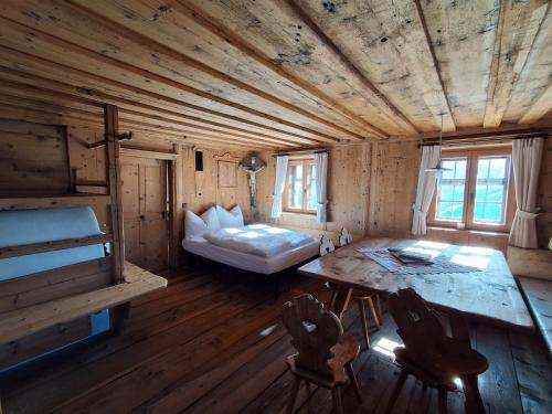 a room with a bed and a table and chairs at Peintnerhof Percha in Perca