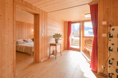 a bedroom with a bed in a wooden house at Appartement dans le Chalet l'Albert in Manigod