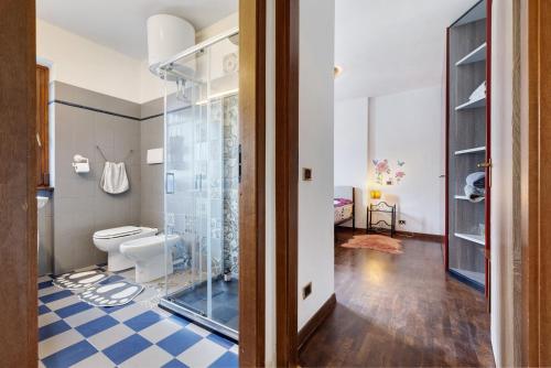 a bathroom with a toilet and a glass shower at Casa Zoe in Arco