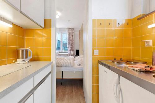 a kitchen with yellow tiles on the walls at Haus Margarete Christel Winkelmann in Cuxhaven
